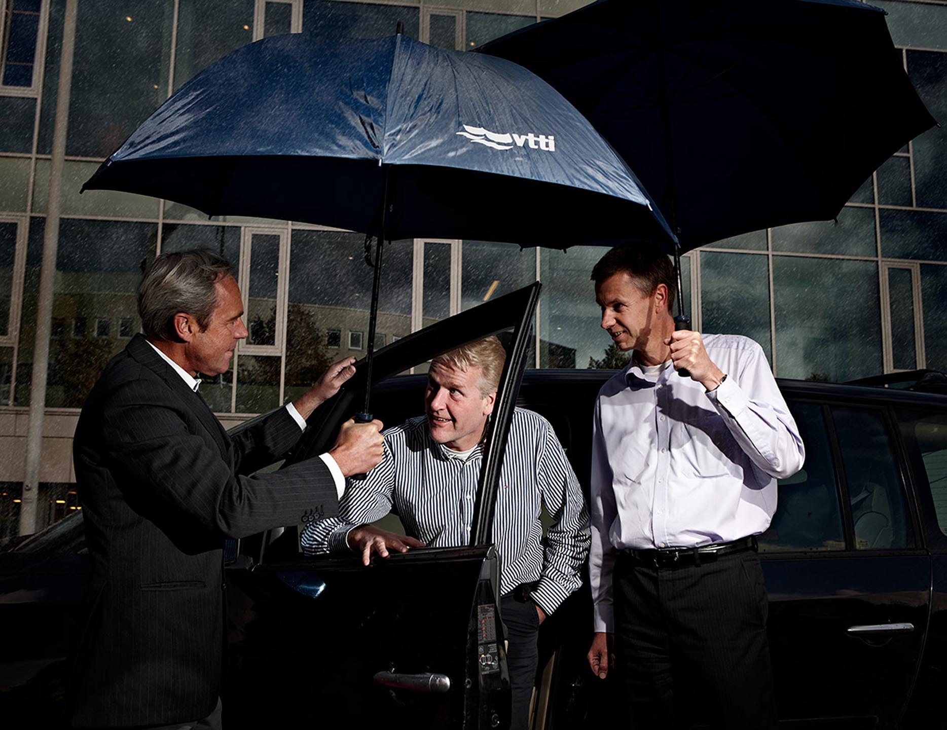 managers in de regen onder paraplu